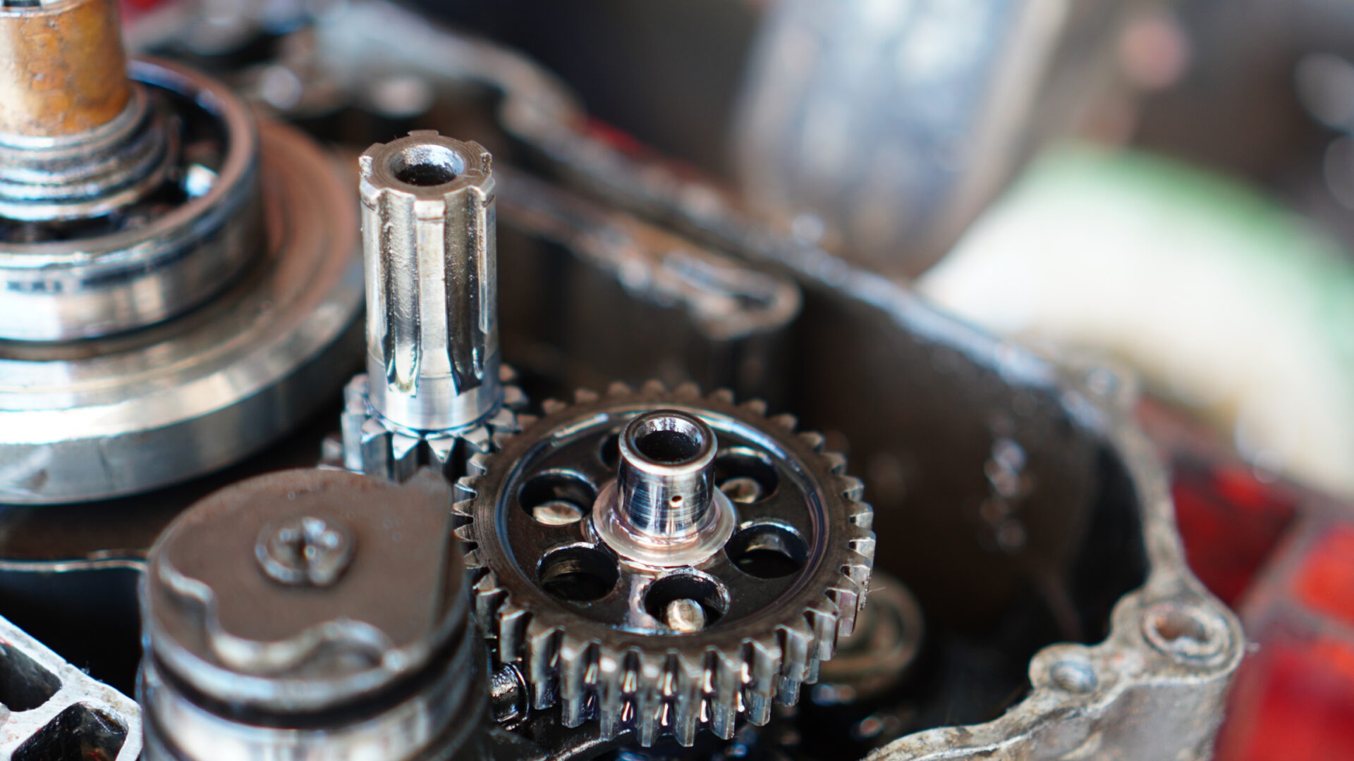 This image features close-up details of metal gears and mechanical parts, presumably from a machinery, with a shallow depth of field blurring the background.